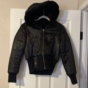 Black puffy jacket with fur inside.